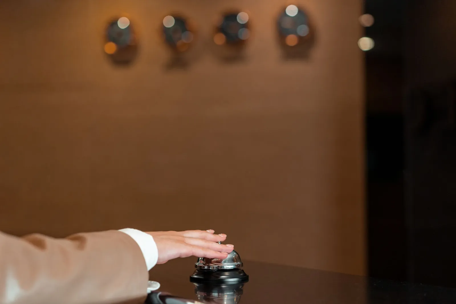 A guest ringing the bell at a hotel reception desk
