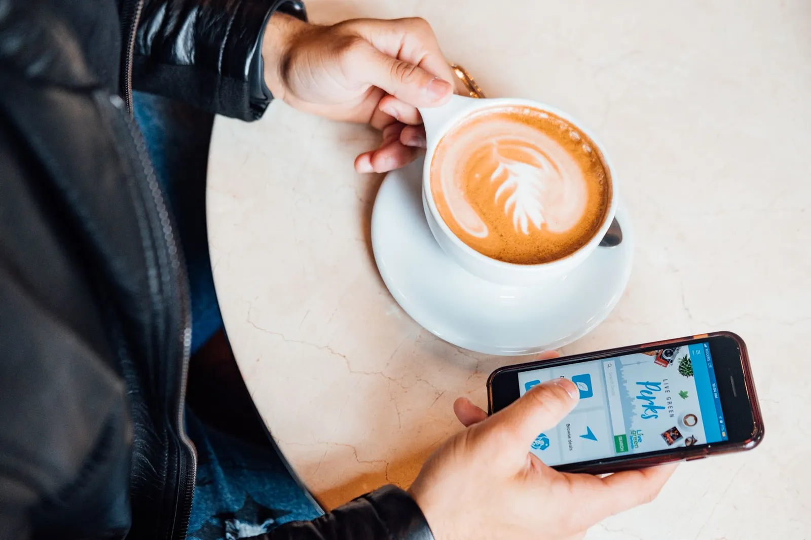 A guest checking their phone over coffee at a cafe